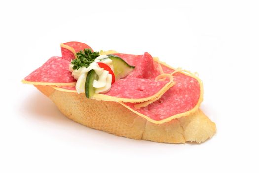 Traditional czech snack called chlebicek. Slices of salami and cucumber with mayonnaise decoratively laid on small soft white bread.