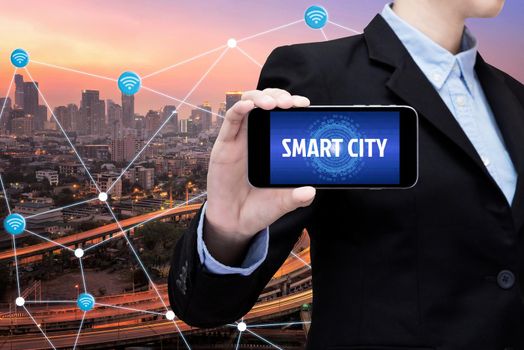 Young Smart business woman is using smart technology of internet of things in smart city for global business connection. Photo design for smart city and smart technology internet of things concept