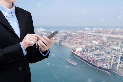 Smart Business woman use smartphone and internet of things technology with shipping boat at shipping yard for Global business container cargo shipping,Logistic,Import  and Export business concept