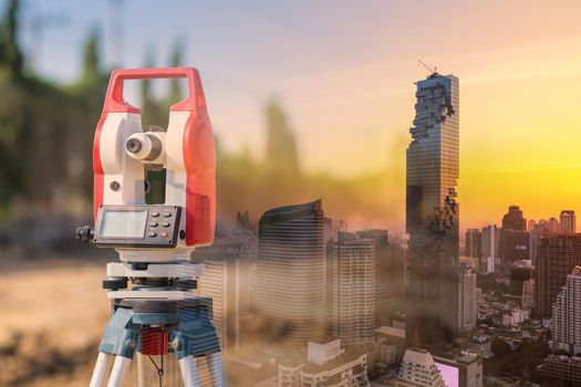 Double exposure surveyor equipment theodolite outdoors with modern building for construction engineering work concept 