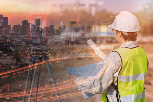 Double exposure of construction engineer checking construction drawing at site area and modern downtown cityscape for Infrastructure construction project concept 