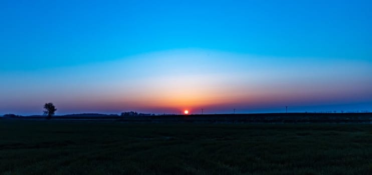 Beautiful sunrise at morning over huge green fields