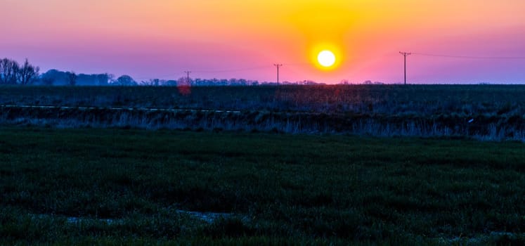 Beautiful sunrise at morning over huge green fields