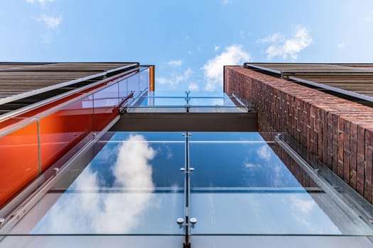 Upward view to to facade of glassy balconies of small building