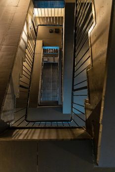 Upward view to rectangular spiral staircase with black metal railings