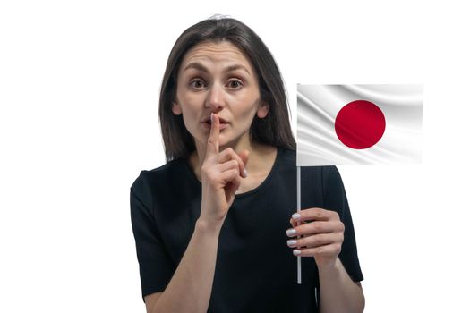 Happy young white woman holding flag of Japan and holds a finger to her lips isolated on a white background.