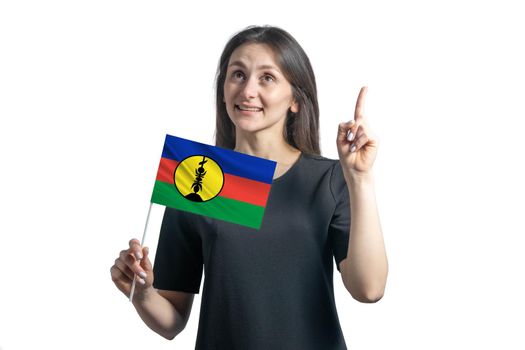 Happy young white woman holding flag of New Caledonia and points thumbs up isolated on a white background.