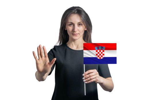 Happy young white woman holding flag of Croatia and with a serious face shows a hand stop sign isolated on a white background.