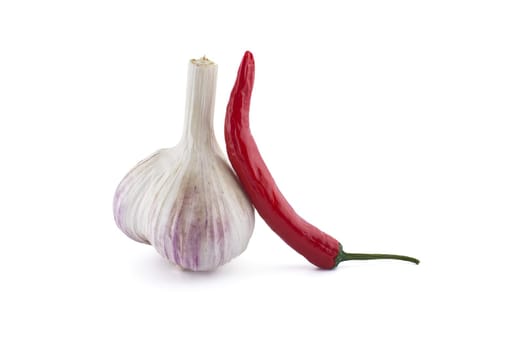 Garlic bulb and fresh small red chili pepper in close-up isolated on white background
