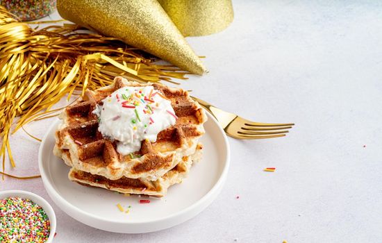 Birthday party waffles decorated with youghurt and colorful sprinkles