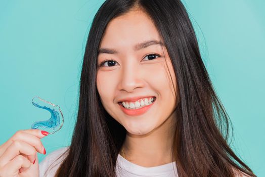 Portrait young Asian beautiful woman smiling holding silicone orthodontic retainers for teeth, Teeth retaining tools after removable braces, Orthodontics dental healthy care concept 