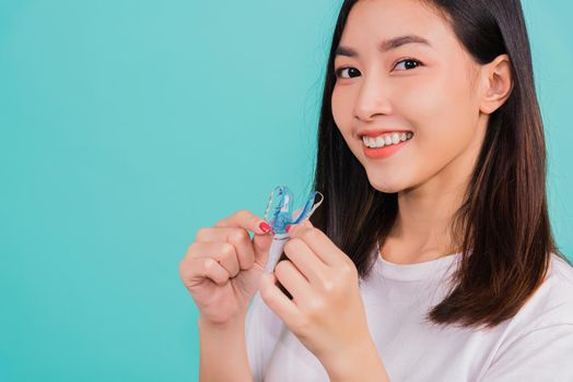 Teeth retaining tools after removable braces, Portrait young Asian beautiful woman smiling holding silicone orthodontic retainers for teeth, Orthodontics dental healthy care concept