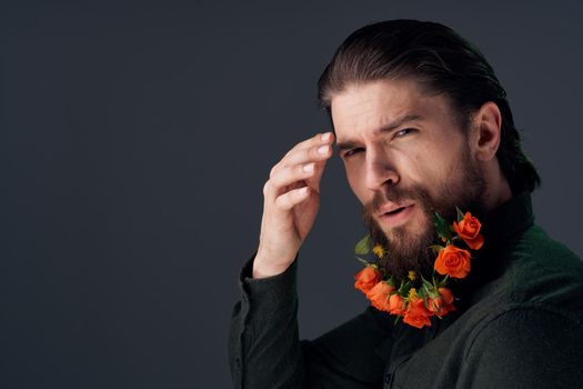 handsome man flowers in a beard decoration romance dark background. High quality photo