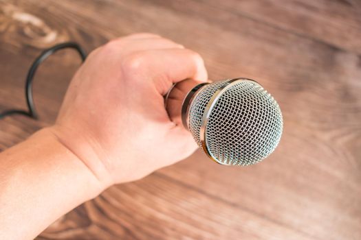 Man holding a karaoke microphone in his hand while performing