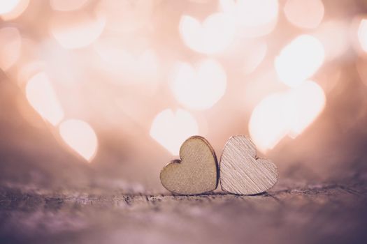 Two handmade wooden hearts on beautiful bokeh background. Vintage style. Love Valentine's Day concept.