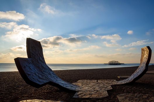 BRIGHTON, UK - CIRCA NOVEMBER 2010: Passacaglia sculpture by Charles Hadcock and the West Pier at sunset.