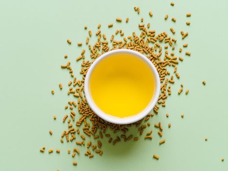 cup of buckwheat tea on light green background. Top view of healthy soba tea over groats on green paper background. Flat lay. Copy space