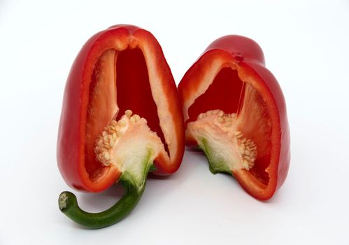 Two halves of red bell pepper in a cut on a white background.
