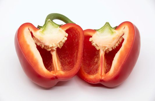 Two halves of red bell pepper in a cut on a white background.