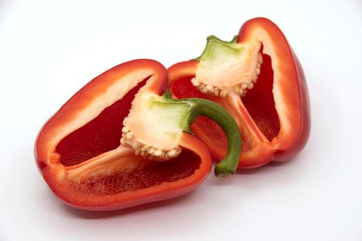 Two halves of red bell pepper in a cut on a white background.