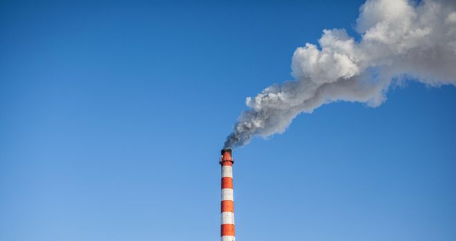 White thick smoke from the boiler room chimney. Smoke against the blue sky. Air pollution. Heating of the city. Industrial zone.