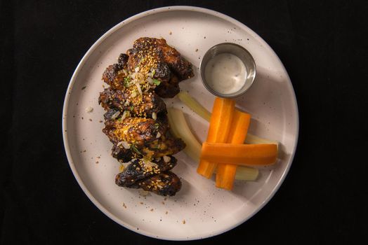Chicken wings in Mexican style on white plate.