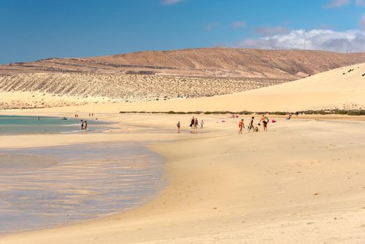 Sotavento, Fuerteventura, Spain: 2020 October 8: Young Blonde Woman walks through the dunes at Playa de Sotavento, Fuerteventura in Spain in summer.