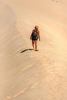 Sotovento, Fuerteventura, Spain: 2020 October 8: Young Blonde Woman walks through the dunes at Playa de Sotavento, Fuerteventura in Spain in summer.