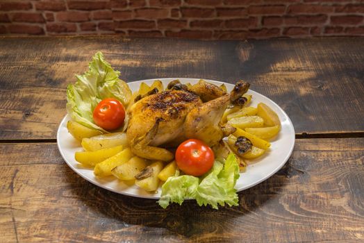 Chicken plate with potatoes with rustic wooden background.