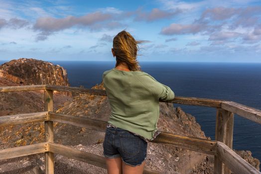 Blonde woman in the View Point in La Entallada lighthouse on the island of Fuerteventura, Spain.