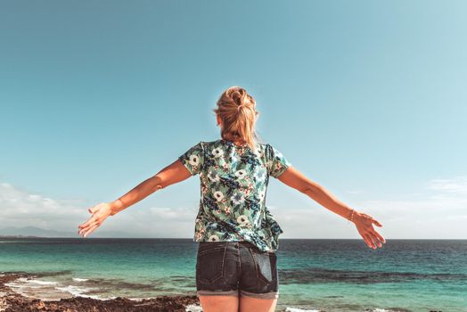 Young blonde woman enjoying the blue sea.