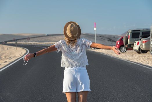 Corralejo, Fuerteventura, Spain: 2020 September 30: Blonde Tourist Girl with hat in the Parque Natual Dunas de Corralejo on Fuerteventura in Canary Islands in Spain.