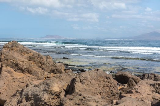 Sunny day on the coast of Fuerteventura where you can see Lanzarote in the distance in the Canary Islands in Spain.