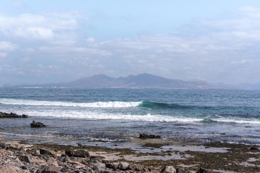 Sunny day on the coast of Fuerteventura where you can see Lanzarote in the distance in the Canary Islands in Spain.