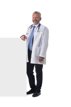 Full length portrait of a mature caucasian male doctor nurse with blank banner isolated on white background