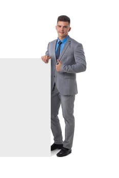 Full length portrait of young man in suit showing banner whiteboard sign isolated on white background