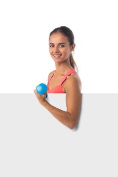 Healthy hispanic fitness girl with dumbbells and blank banner isolated on white background