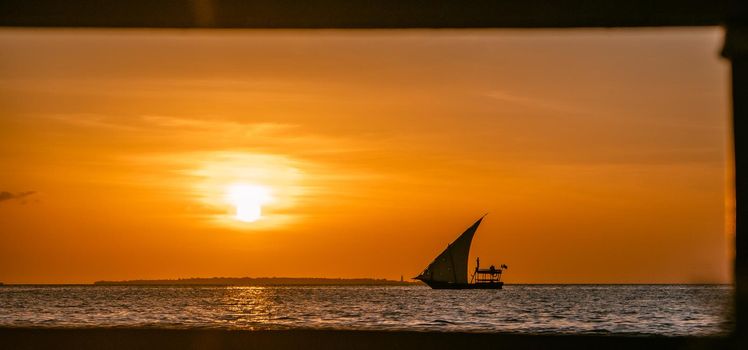View on the ocean with sunset and silhouette of boat. High quality photo