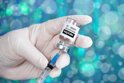 Coronavirus Covid-19 Vaccine. Doctor filling syringe injection with vaccine from the bottle for patient vaccination in medical clinic, Coronavirus in background