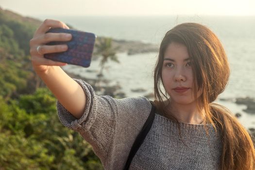 Young woman traveling around Goan coastline beach in India county.