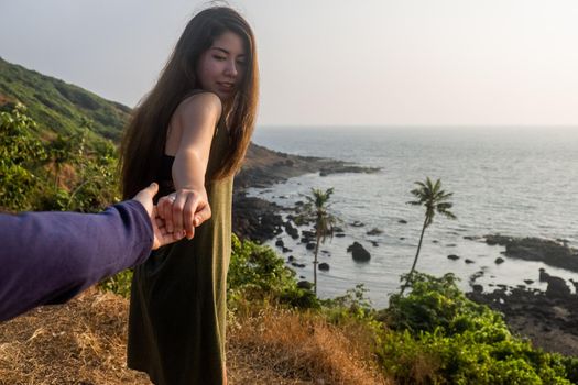 Shot of a young woman leading someone by the hand at the beach