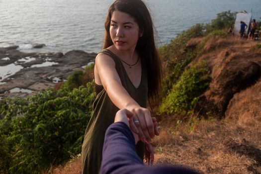 Shot of a young woman leading someone by the hand at the beach