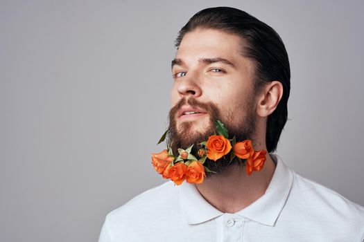 Elegant man in a white shirt flowers in a beard decoration emotions studio light background. High quality photo