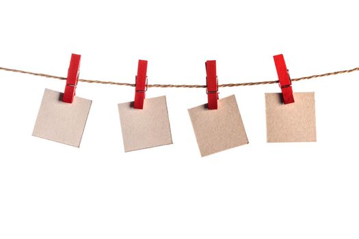 Four paper blank notes hanging on the rope isolated on white background