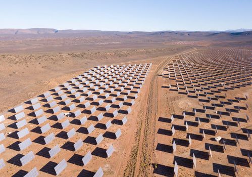 Aerial over solar panels in a dry landscape