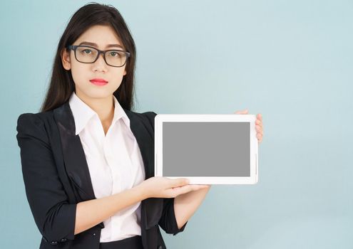 Young asian women in suit holding her digital tablet standing against green background