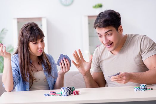 Young family playing cards at home