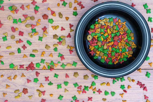 Top view dry cat food in bowl on wooden background