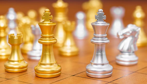 Gold king chess piece and various chess pieces stand on wood chessboard ,Concept of leadership game of strategy