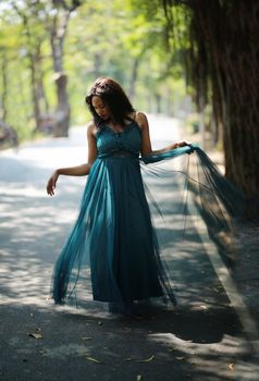 Cheerful young woman standing by tree in the jungle. 